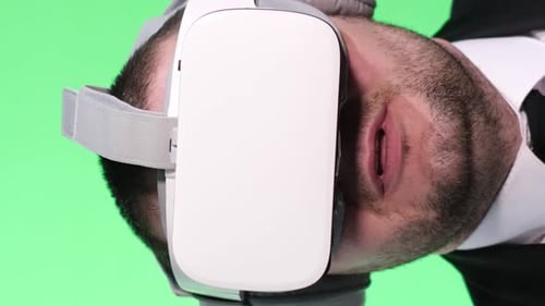 Satisfied Virtual Player A Young Man on Green Takes Off Virtual Glasses Vertical Video