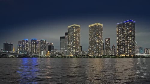 Night Cityscape with Reflective Water and Towering Buildings