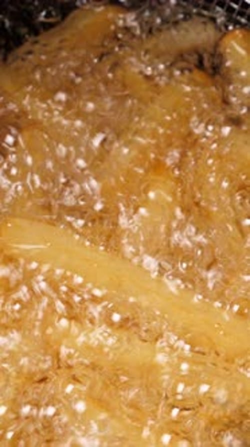 Cooking French Fries Potatoes in Deep Fryer Closeup Vertical