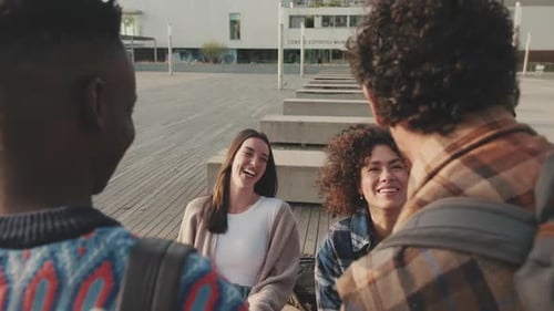 Young people laughing and chatting from outside next to the university