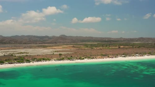 The white sand beach of Tanjung Aan in Lombok, Indonesia during a sunny day. Aerial shot.