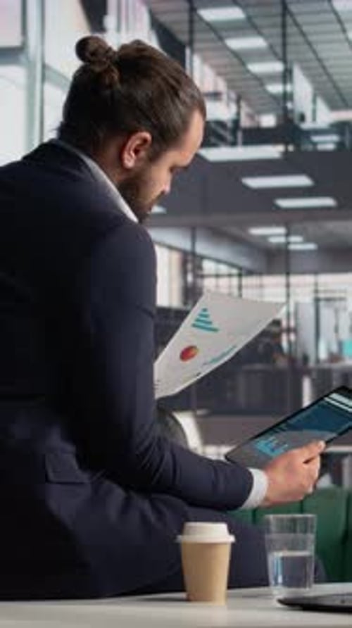 Man in Suit Analyzes Data at Modern Office