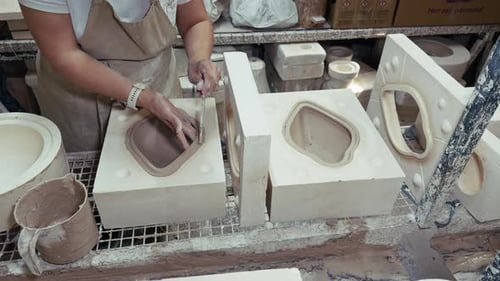 Keramischer Handwerker, der in der Töpferwerkstatt mit Gipsformen arbeitet 3
