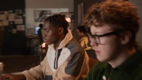 Multiethnic Programmers Coding on Laptops in Office at Night