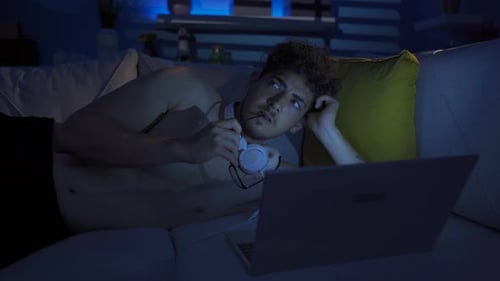 Young Man Video Chatting on Laptop at Night