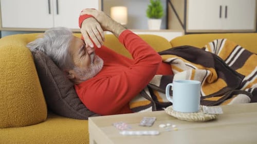 Mature Man Resting on Couch with Flu Symptoms