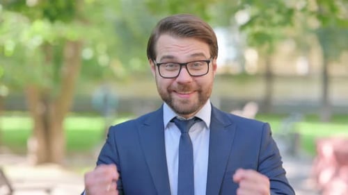 Man Celebrates Success in an Urban Park