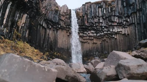 Wide, low angle slow motion 120fps clip of Svartifoss Waterfall, Iceland.