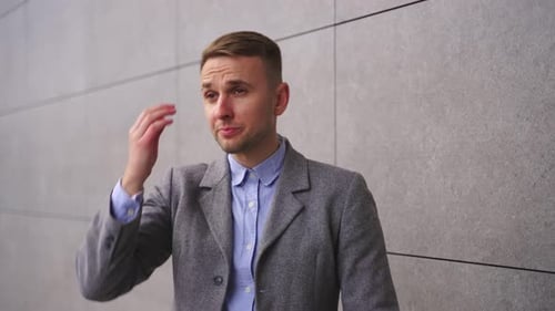 Smiling Young Man in Suit Jacket Adjusts Sleeves