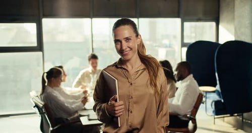 Happy Successful Businesswoman in Business Brown Clothes Smiling Looking at the Camera in the Office