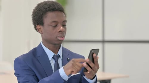 Excited Young Adult Businessman Using a Mobile Phone