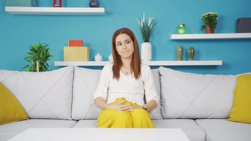 Woman Sitting Looking Pensive on Couch