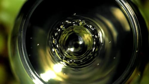 Ein Tropfen fällt in ein Glas Weißwein, gefilmt mit einer Hochgeschwindigkeitskamera mit 1000 Bildern pro Sekunde