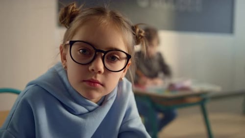 Serious Girl Portrait at School. Pretty Student in Eyeglasses Looking at Camera