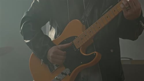 Rock Musician in Leather Jacket Playing Electric Guitar in Studio