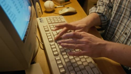 Anonymer Mann arbeitet auf einem Computer der 1990er Jahre an einer Tabelle