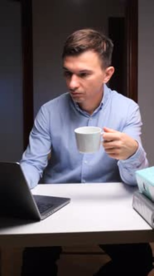 Young Man Working on Laptop with Coffee Indoors