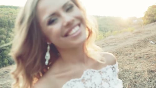 Blonde Woman Smiling in White Dress at Sunset