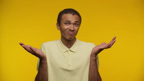 Young Adult with I Don't Know Expression on Yellow