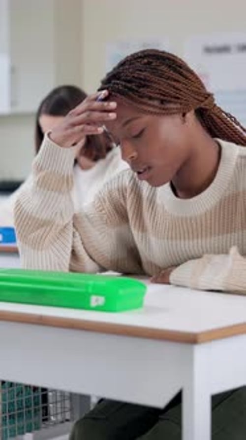 Student, stress and writing exam with scholarship, thinking and anxiety in classroom for education