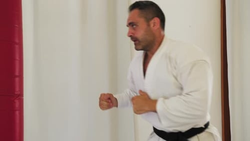 Man Practicing Karate in White Gi and Belt