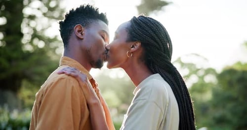 Happy, garden and black couple with kiss in nature for romance date on vacation or holiday