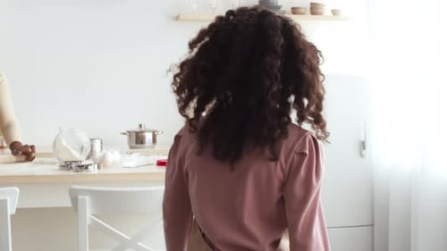 Mother and Daughter Baking Pastries Together at Home in the Kitchen