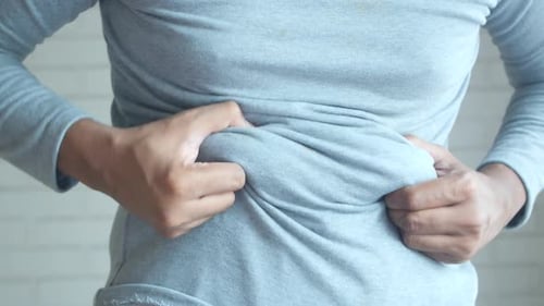 Adult Grabbing Stomach Wearing a Blue Shirt