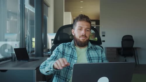 Tired Office Worker Removing Glasses and Leaning Back in Chair After Completing Tasks on Laptop