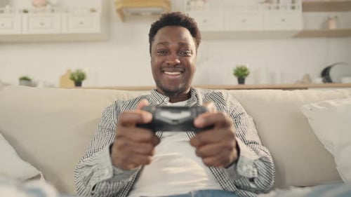 Young Man Plays Video Game on Sofa