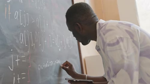 Man Writing Math Equations on Chalkboard