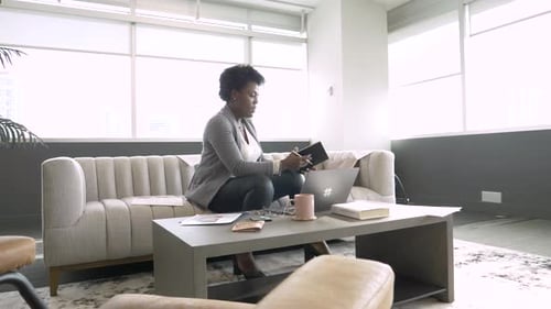 Businesswoman with Notebook Working at Laptop in Office Lobby Adult