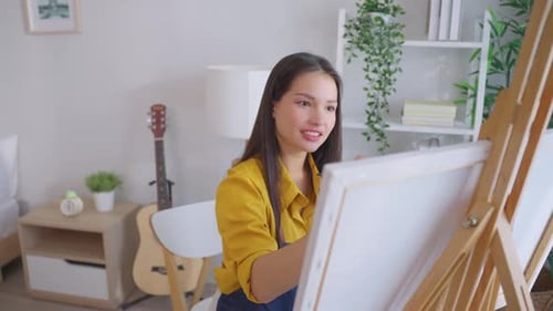 Woman Painting on Canvas Indoors