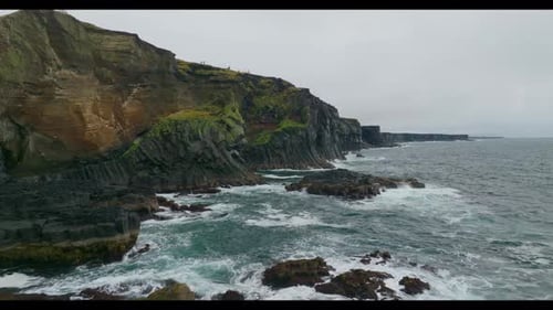 Aerial view of wild coastline with cliffs and rock formation in Iceland.