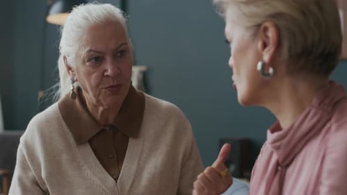 Two Senior Women Talking Indoors in a Home