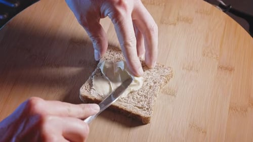 Hands Spread Cream Cheese onto Slice of Bread