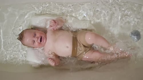 Happy Infant Splashing in Bathtub Water
