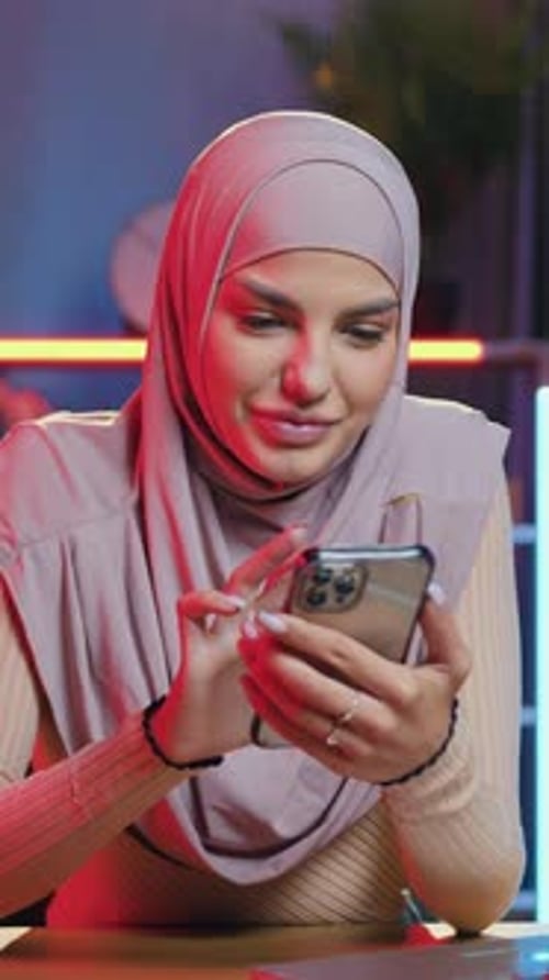 Young Woman in Headscarf Using Mobile Phone Indoors