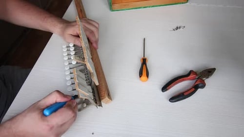 Man Repairing Accordion Keyboard with Tools