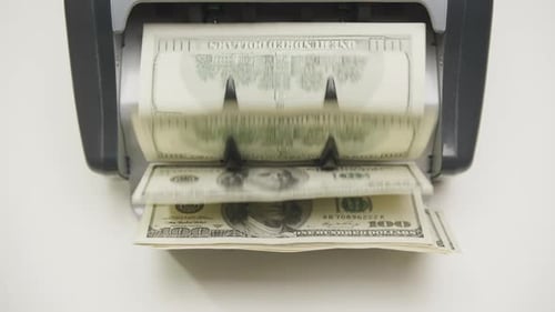 Closeup of US Dollar Banknotes in Money Counting Machine