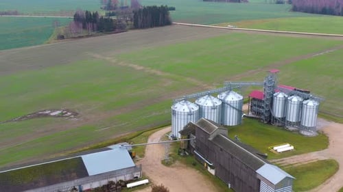 Silos à grains modernes dans une immense ferme entourée de champs agricoles, vue aérienne