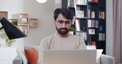 Man Working at Home on Laptop Computer