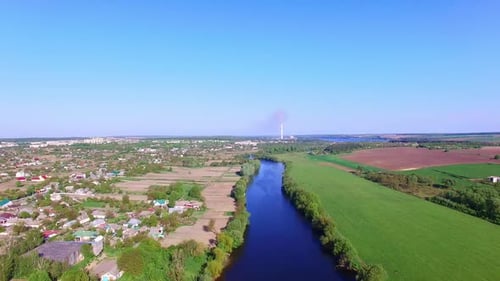Large village with private houses outlined by thin blue river.