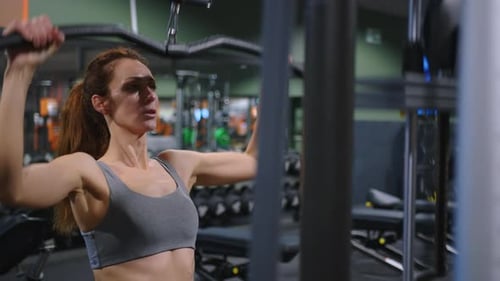 A Modern Advanced Woman Performs Sports Exercises in the Gym to Maintain a Beautiful Body Shape and