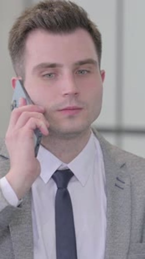 Young Man in Suit Talking on Cell Phone