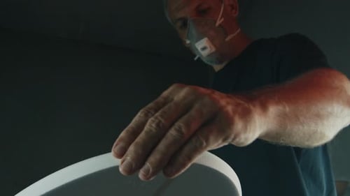 Surf board factory. Adult male shaper creates the surfing board on the factory