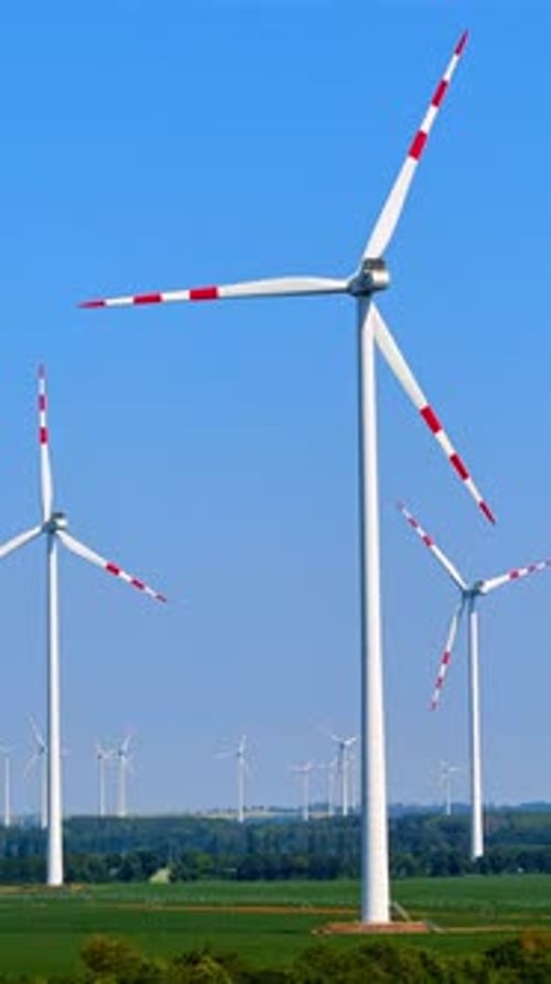 Blades of wing turbines with red lines rotate slowly in the wind. Green energy production concept