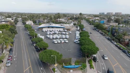 Aerial Slide and Pan Footage of Carpark with Post Vans and Surrounding Streets in Urban Borough