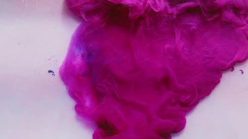 Purple Ink Pouring and Flowing in White Liquid