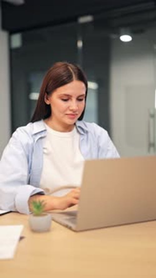 Woman working on laptop takes a break at desk